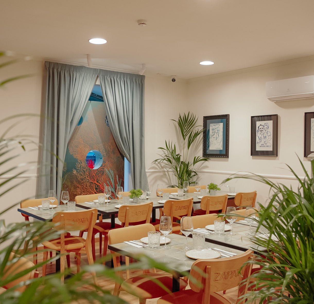 Comedor con mesas puestas y plantas
