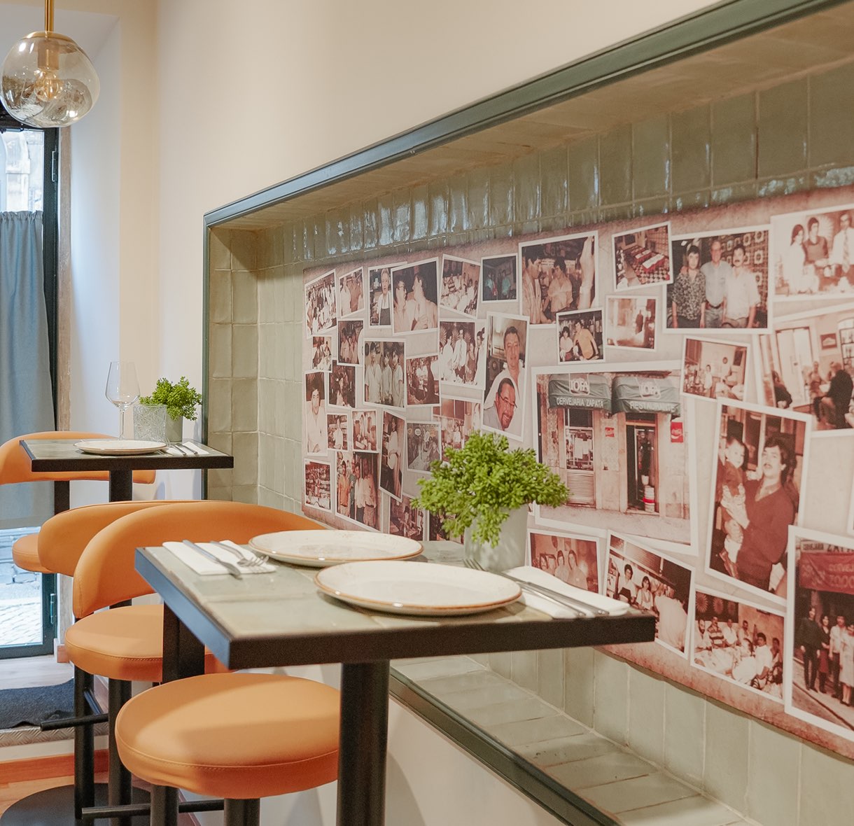 Sala con mesas puestas y una pared cubierta de fotografías familiares